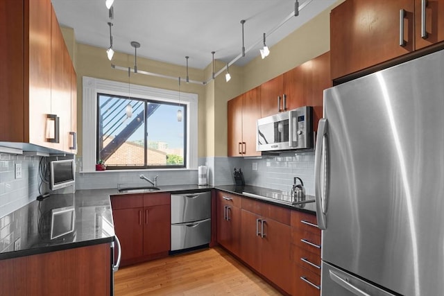 258 Shawmut Ave Unit 8, Boston, MA 02118 - kitchen featuring stainless steel appliances, track lighting, decorative backsplash, light wood-type flooring, and a sink