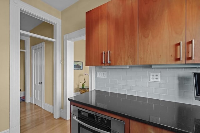 258 Shawmut Ave Unit 8, Boston, MA 02118 - kitchen with oven, light wood-type flooring, backsplash, baseboards, and dark stone counters