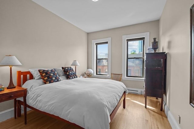 258 Shawmut Ave Unit 8, Boston, MA 02118 - bedroom with light wood finished floors, a baseboard heating unit, and baseboards