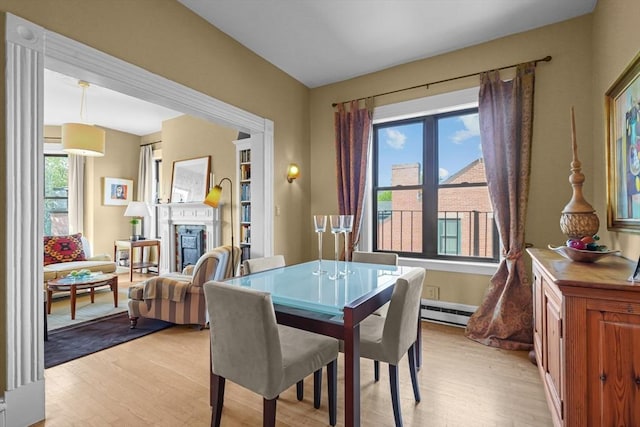 258 Shawmut Ave Unit 8, Boston, MA 02118 - dining area featuring a baseboard heating unit, light wood finished floors, and a glass covered fireplace