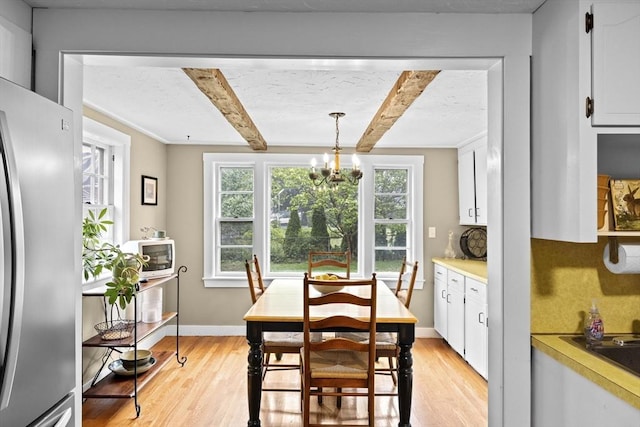 23 Garden Rd, Scituate, MA 02066 - dining area featuring light wood-style floors, beamed ceiling, and a chandelier