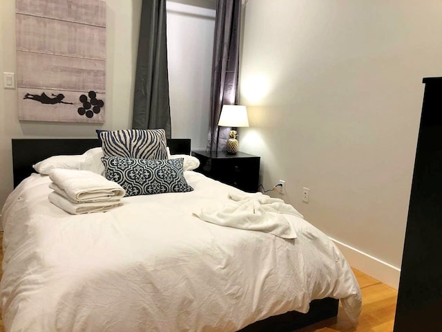 bedroom featuring baseboards and wood finished floors