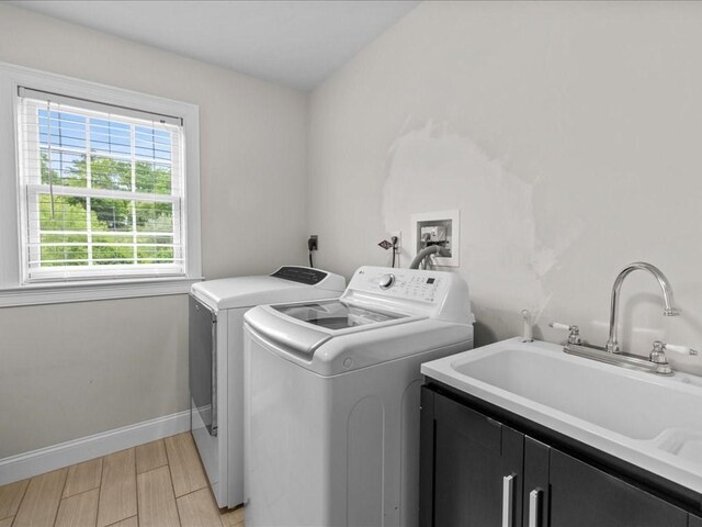 10 Beech St, Millis, MA 02054 - laundry area with cabinet space, washing machine and clothes dryer, baseboards, and light wood-style floors