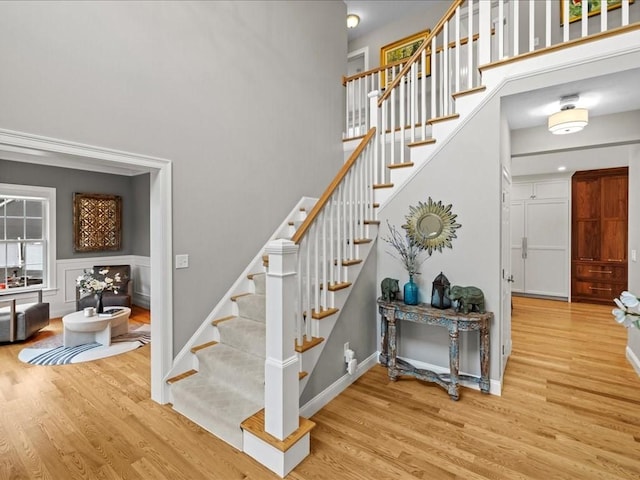 10 Beech St, Millis, MA 02054 - staircase featuring wood finished floors, a towering ceiling, and baseboards