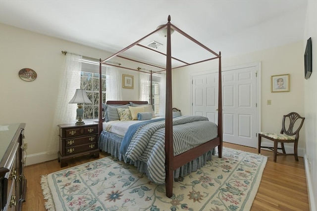 bedroom featuring visible vents, baseboards, and wood finished floors