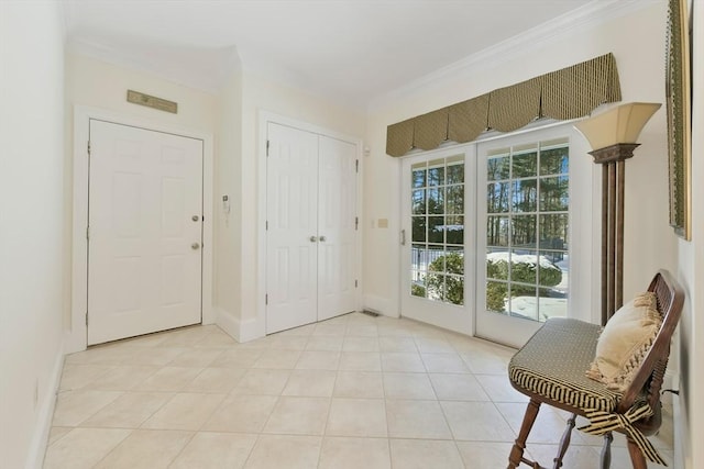 entryway with light tile patterned floors, baseboards, and crown molding