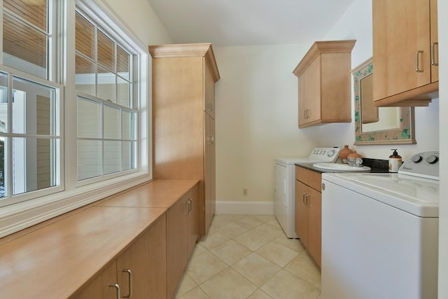 washroom featuring baseboards, light tile patterned flooring, cabinet space, and washer and dryer