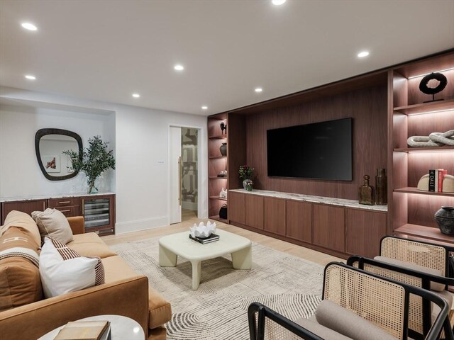 living room featuring built in shelves, wood walls, and light hardwood / wood-style flooring