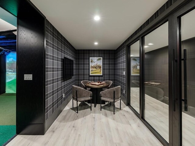 dining room with tile walls and wood-type flooring