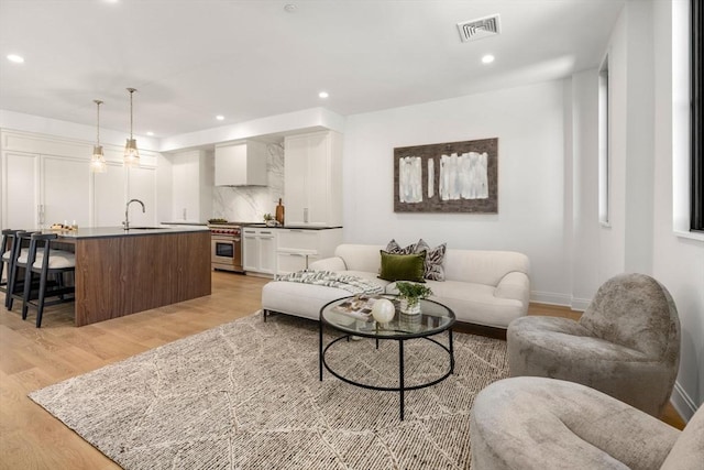 living room featuring light hardwood / wood-style floors and sink