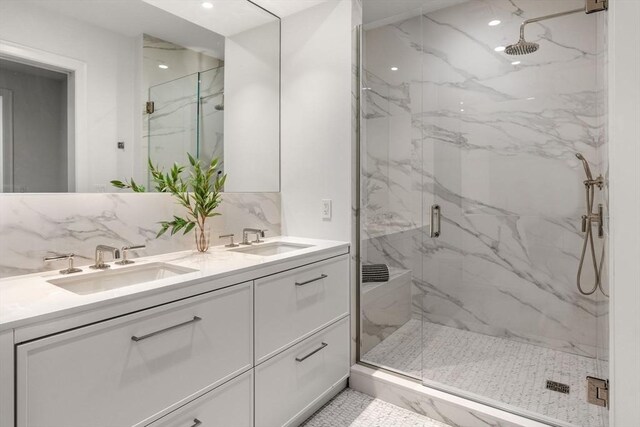 bathroom featuring tasteful backsplash, vanity, and a shower with shower door