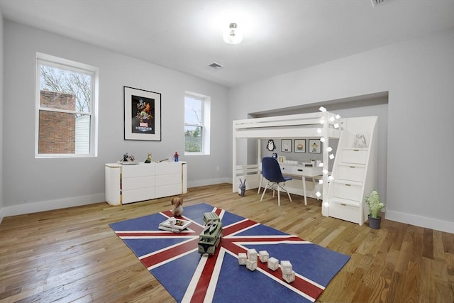 bedroom featuring visible vents, baseboards, and wood finished floors