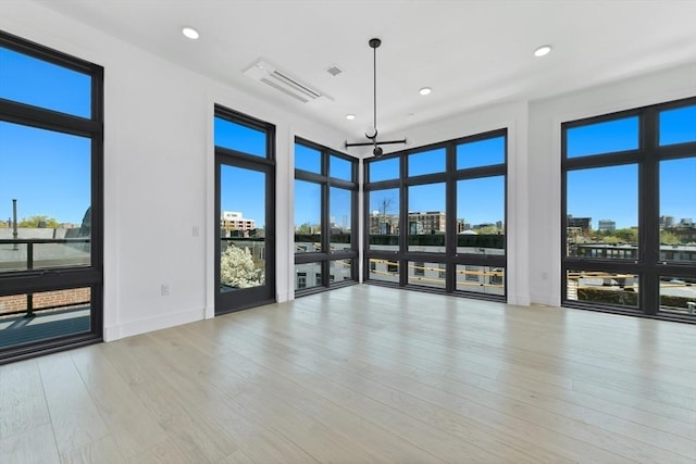 spare room featuring a view of city, recessed lighting, and visible vents