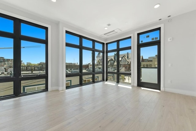 spare room with recessed lighting, baseboards, visible vents, and wood finished floors