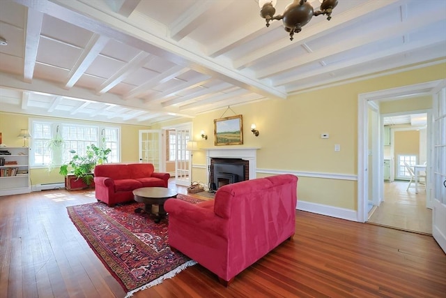 living area featuring baseboards, a baseboard radiator, wood finished floors, beamed ceiling, and a fireplace