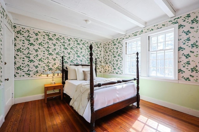 bedroom with baseboards, hardwood / wood-style flooring, beam ceiling, and wallpapered walls