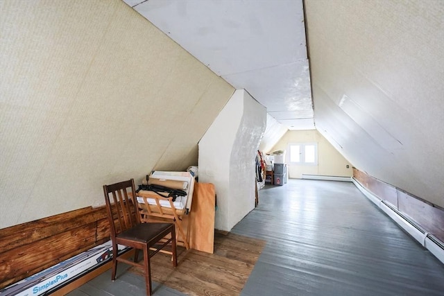 additional living space featuring a baseboard heating unit, vaulted ceiling, and wood finished floors