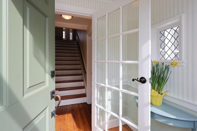 doorway featuring wallpapered walls, stairway, and wood finished floors