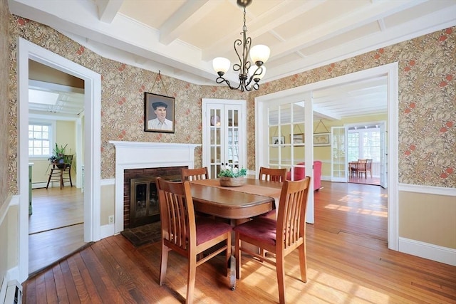 dining area featuring wallpapered walls, wainscoting, hardwood / wood-style floors, french doors, and beam ceiling