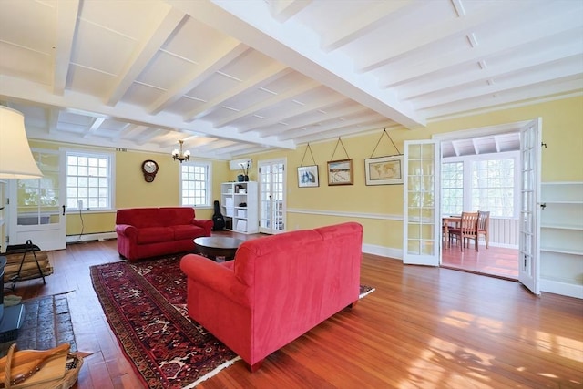 living area featuring french doors, beamed ceiling, baseboard heating, and hardwood / wood-style flooring