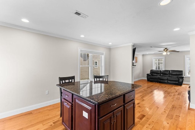 kitchen featuring crown molding, light wood-style flooring, and visible vents