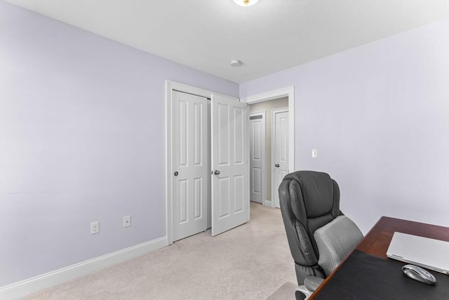 office area featuring baseboards and light colored carpet