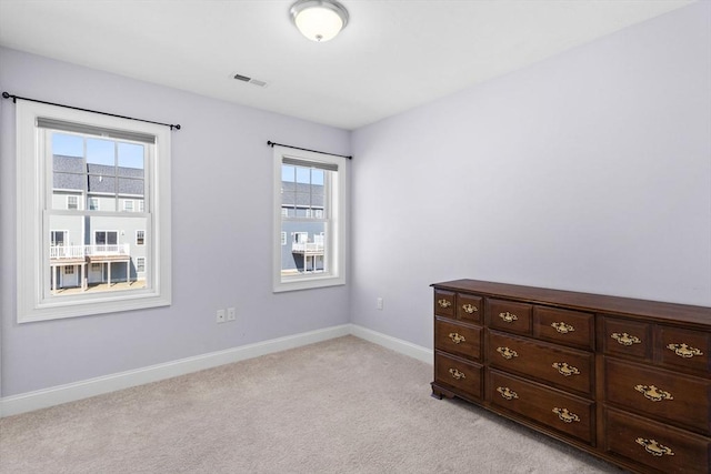 interior space featuring visible vents, baseboards, and light colored carpet