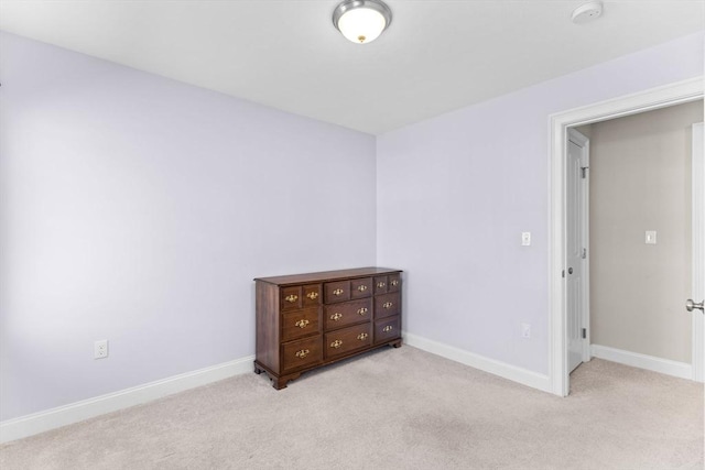 bedroom with light carpet and baseboards