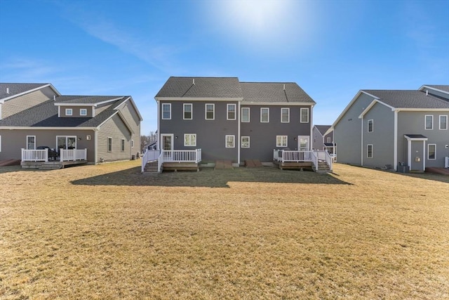 rear view of property with a deck and a yard