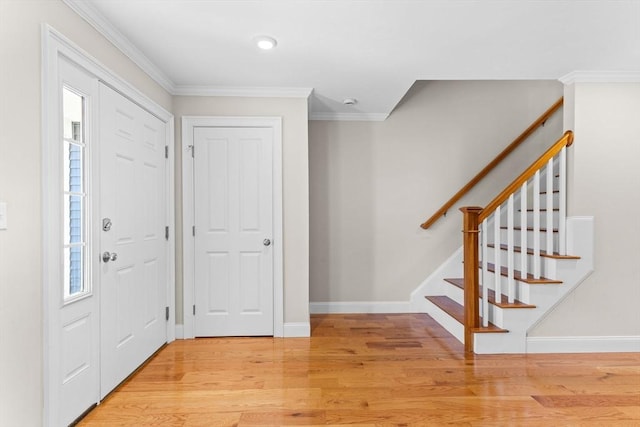 foyer with stairs, baseboards, crown molding, and light wood finished floors