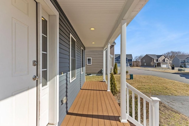 wooden deck with a residential view and covered porch