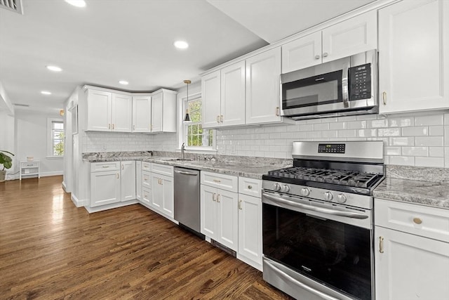 kitchen featuring appliances with stainless steel finishes, plenty of natural light, and white cabinets
