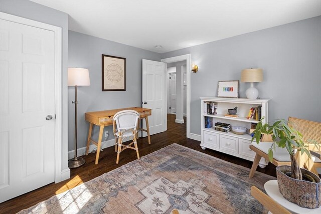 sitting room with baseboards and wood finished floors