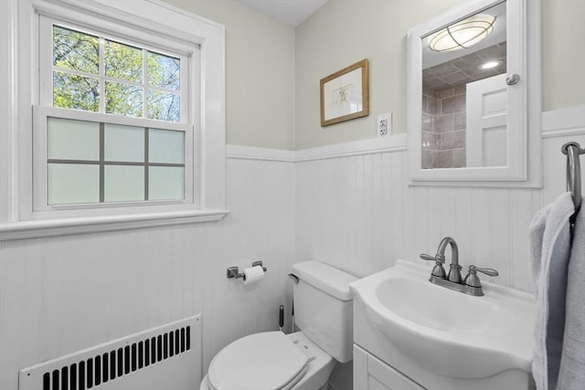 bathroom with toilet, wainscoting, radiator, and vanity