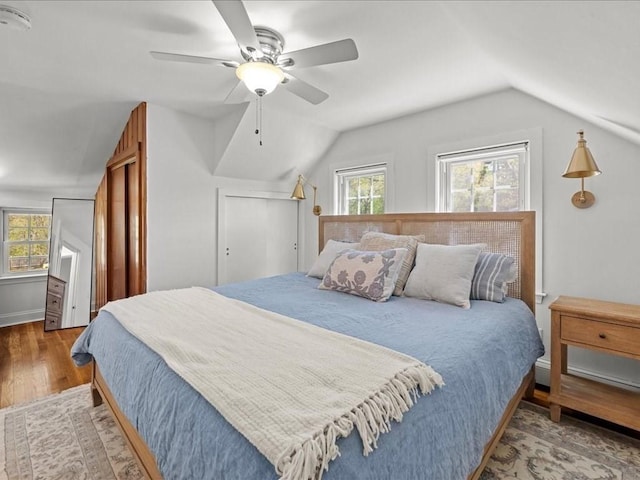 bedroom with baseboards, ceiling fan, vaulted ceiling, and wood finished floors