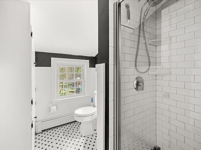 bathroom with a baseboard radiator, toilet, and a shower stall
