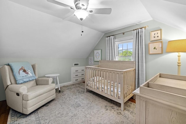 bedroom with a ceiling fan, baseboards, wood finished floors, and lofted ceiling