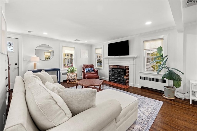 living area featuring a fireplace, radiator heating unit, recessed lighting, visible vents, and ornamental molding