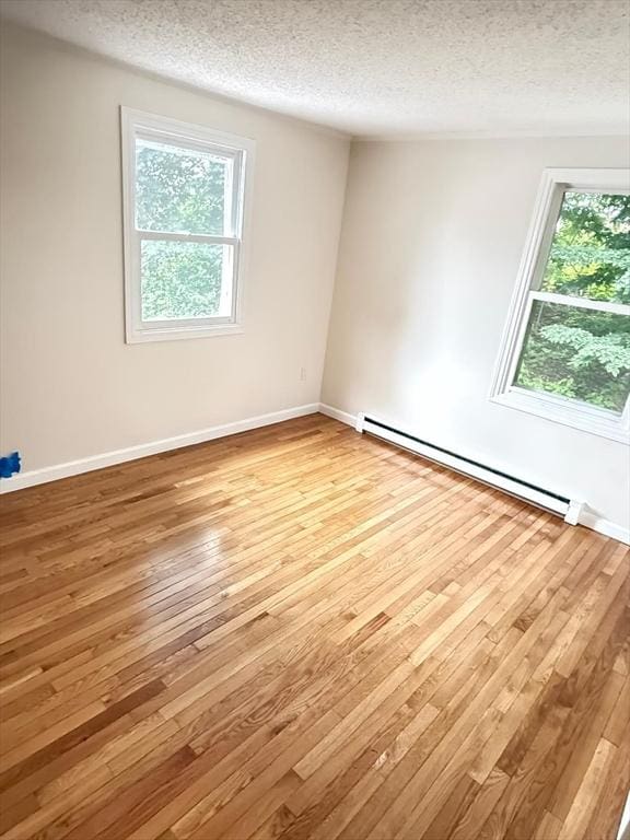 212 Fountain St Unit A, Framingham, MA 01702 - spare room with a baseboard radiator, wood-type flooring, and a textured ceiling