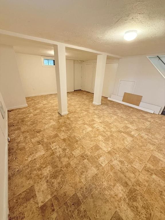 212 Fountain St Unit A, Framingham, MA 01702 - below grade area with a textured ceiling and light stone finish floors