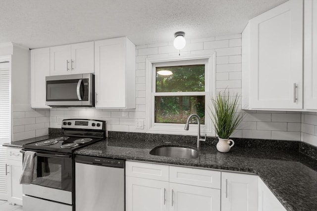 212 Fountain St Unit A, Framingham, MA 01702 - kitchen featuring stainless steel appliances, a textured ceiling, white cabinets, dark stone counters, and backsplash