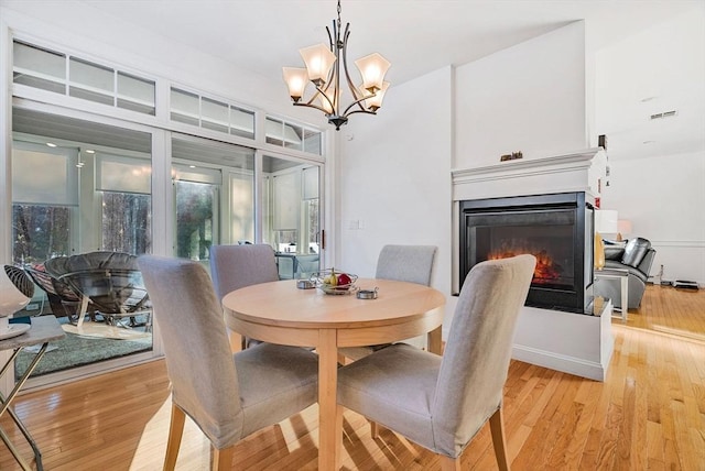 dining area featuring a notable chandelier and light wood-type flooring