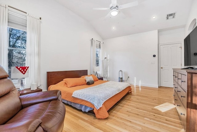 bedroom featuring lofted ceiling, multiple windows, and light hardwood / wood-style floors