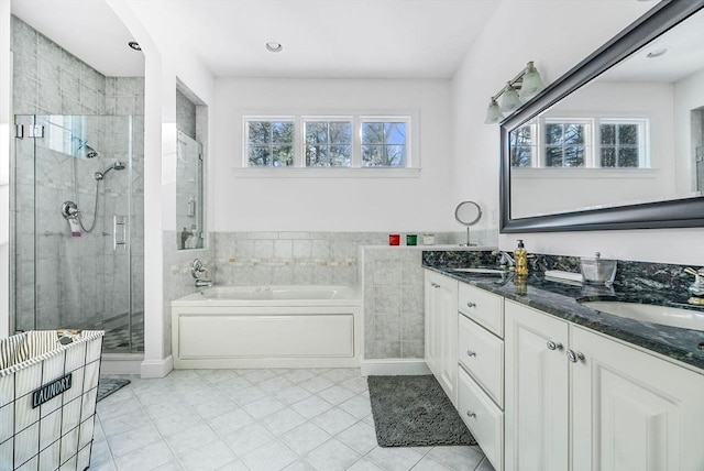 bathroom with independent shower and bath, vanity, and tile patterned flooring