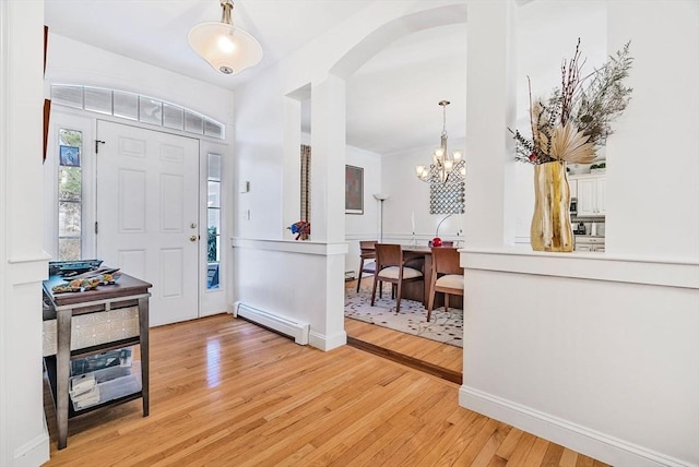 entrance foyer with a notable chandelier, light hardwood / wood-style flooring, and baseboard heating