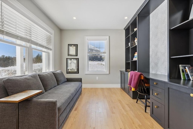 office area featuring light hardwood / wood-style flooring, built in desk, and a healthy amount of sunlight