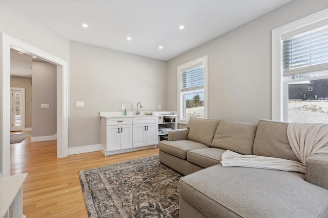 living room with sink and light wood-type flooring