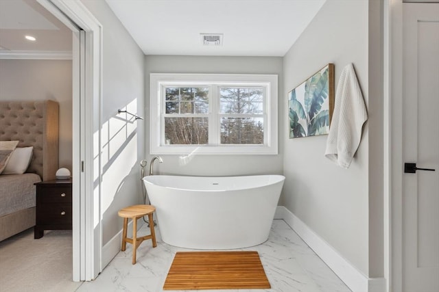 bathroom with crown molding and a bathtub