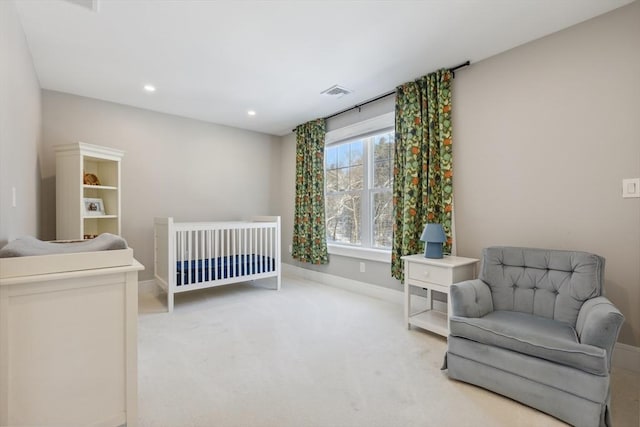 carpeted bedroom with a nursery area