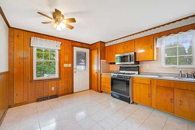 209 Sharp St, Dartmouth, MA 02747 - kitchen with range with gas cooktop, stainless steel microwave, brown cabinets, light countertops, and ornamental molding